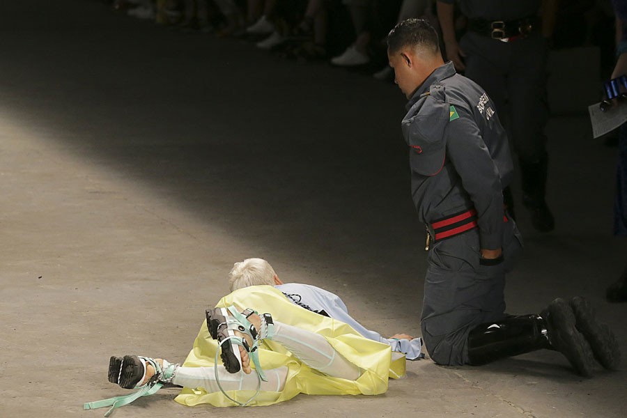 Model Tales Soares lies on the catwalk as a paramedic tends to him after he collapsed during Sao Paulo Fashion Week in Sao Paulo, Brazil, Saturday, April 27, 2019. A statement from organisers said that Soares died after taking ill while participating in the Sao Paulo's Fashion Week -Leco Viana/Thenews2 via AP