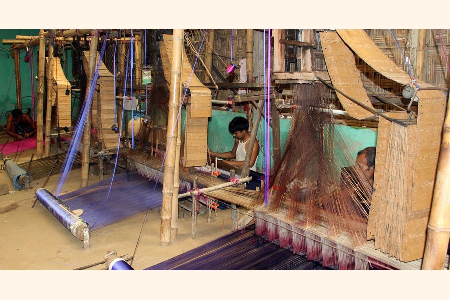 Weavers at Benarasi Palli under Gangachhara upazila in Rangpur passing busy time on Thursday   	— FE Photo