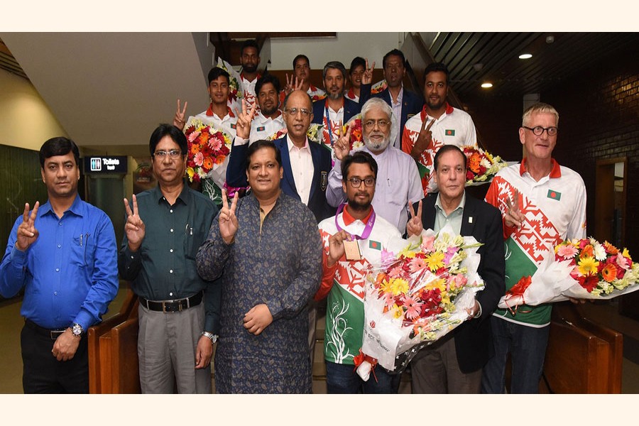 Archer Mohammad Ruman Shana poses for photograph with Bangladesh team at a reception on Tuesday 	—UNB