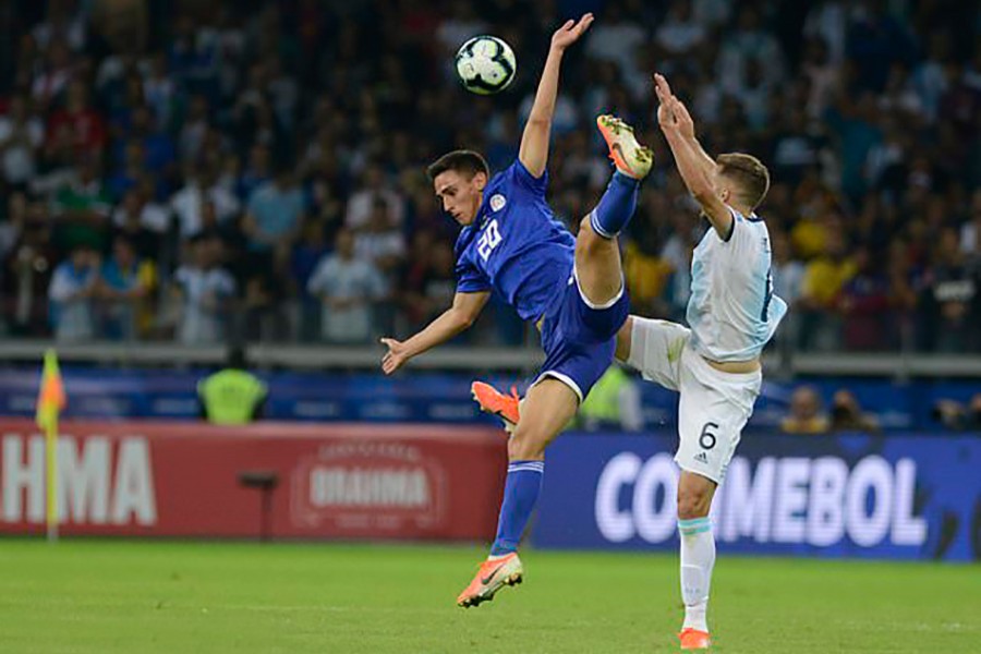 Paraguay's Matias Rojas (left) and Argentina's German Pezzella jump for the ball during a Copa America Group B match at the Mineirao stadium in Belo Horizonte, Brazil, on Wednesday — AP photo