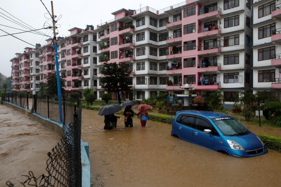 Residents walk towards dry ground from a flooded colony in Kathmandu, Nepal July 12, 2019. REUTERS/Navesh Chitrakar