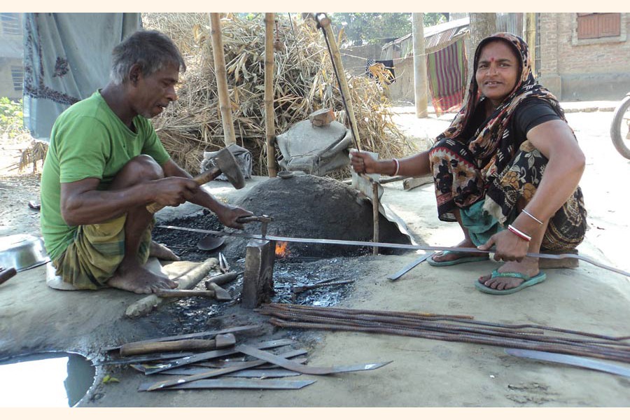 A couple of blacksmith under Panchbibi upazila of Joypurhat busy making varieties of iron tools on Thursday 	— FE Photo