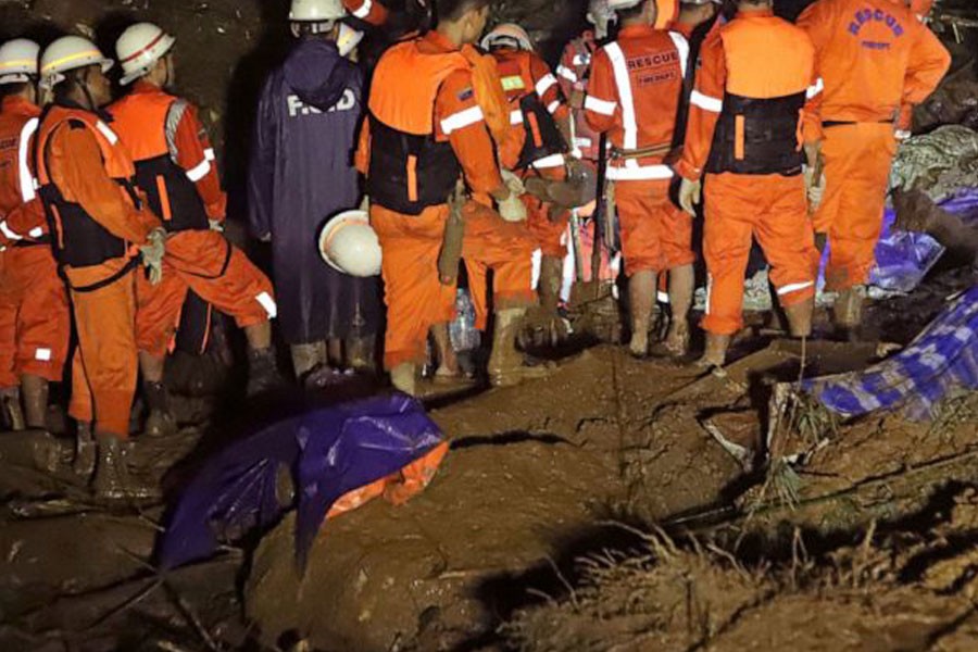 In this Aug. 9, 2019, photo, members of a Myanmar rescue team gather at the landslide-hit area at a village in Paung township, Mon State, Myanmar. A landslide has buried more than a dozen village houses in southeastern Myanmar - AP Photo