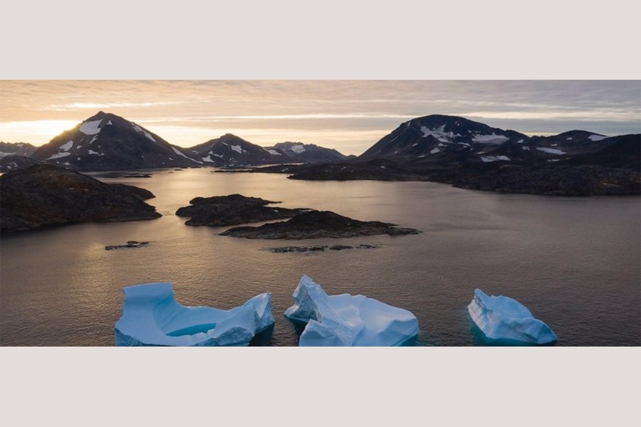 In this August 16, 2019, photo, large Icebergs float away as the sun rises near Kulusuk, Greenland. Scientists are hard at work, trying to understand the alarmingly rapid melting of the ice.    —Photo:  AP