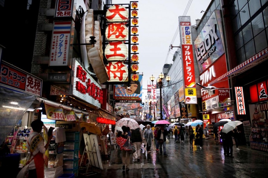 People walk through a shopping district in Osaka, western Japan October 22, 2017 - Reuters