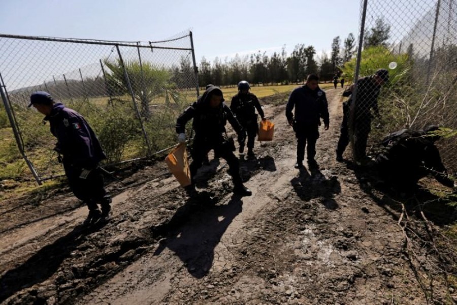 Polices officers look for evidence at a ranch where a firefight took place on Friday in Tanhuato, state of Michoacan, May 23, 2015. REUTERS/Henry Romero/File Photo