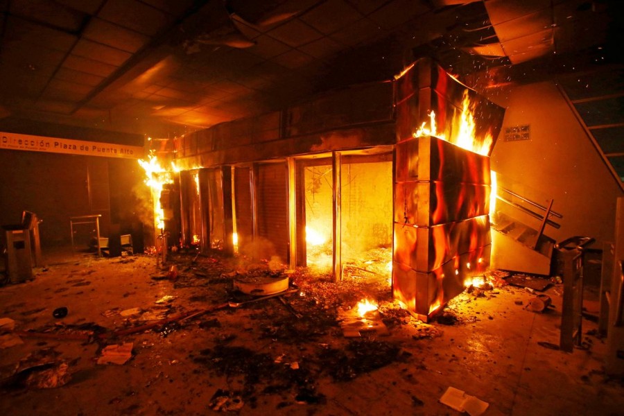 A subway ticket office is seen on fire during a protest against the increase in the subway ticket prices in Santiago, Chile, October 19, 2019 REUTERS/Ramon Monroy