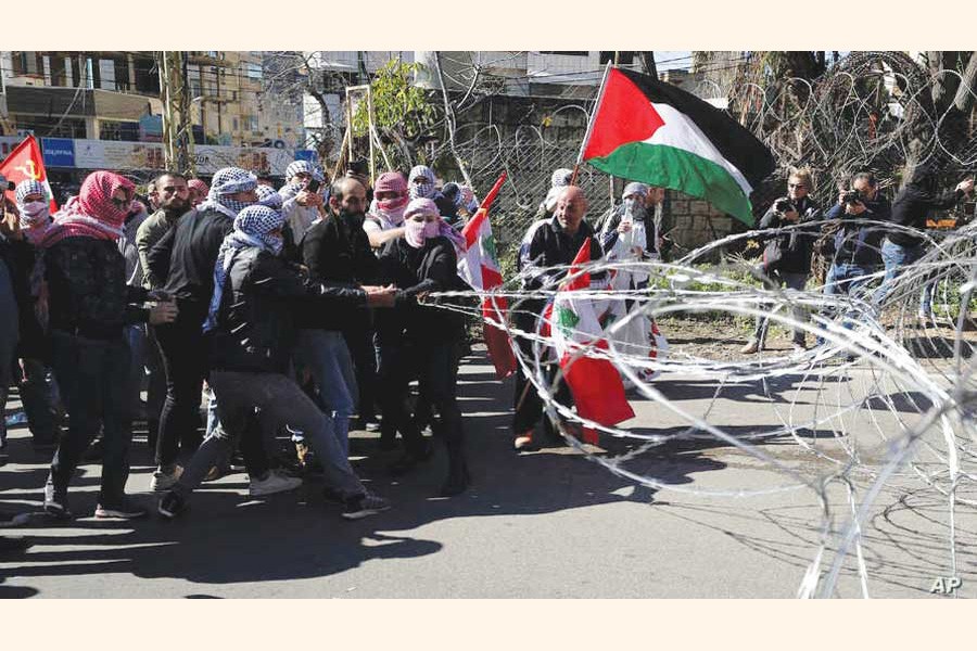 Protesters try to remove barbed wires that block a road leading to the U.S. Embassy during a protest is held against the proposed peace deal for the Middle East by President Donald Trump, in Aukar, east of Beirut, Lebanon on  February 02, 2020. —Photo:  AP