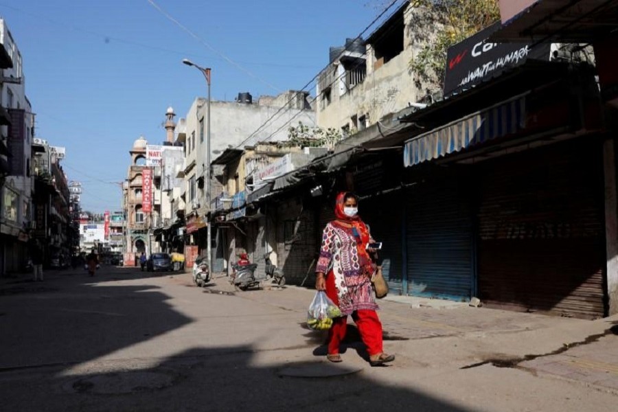 A woman walks along a near-empty street during a lockdown amid a coronavirus disease (COVID-19) outbreak in New Delhi, India, March 25, 2020. — Reuters