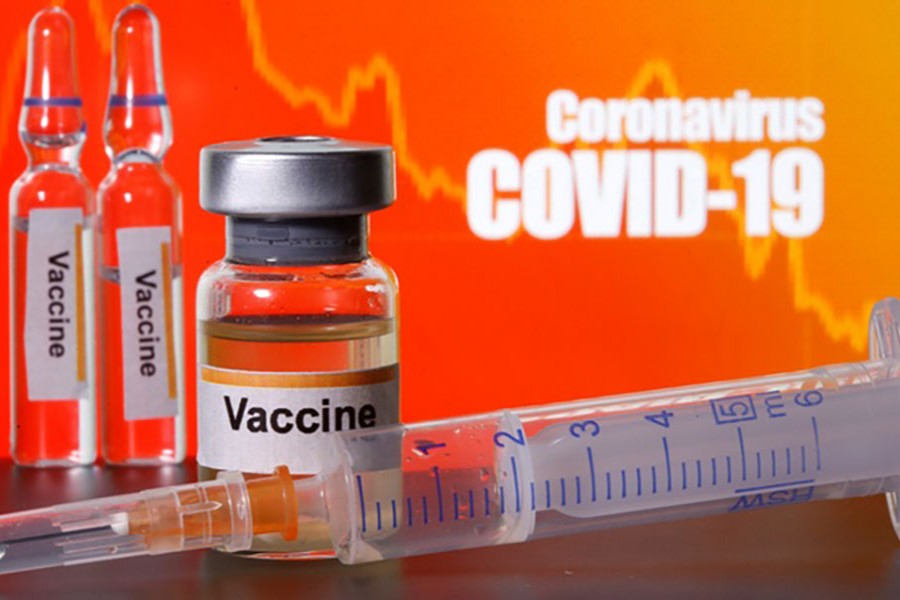 Small bottles labelled with "Vaccine" stickers stand near a medical syringe in front of displayed "Coronavirus COVID-19" words in this illustration taken April 10, 2020. Reuters