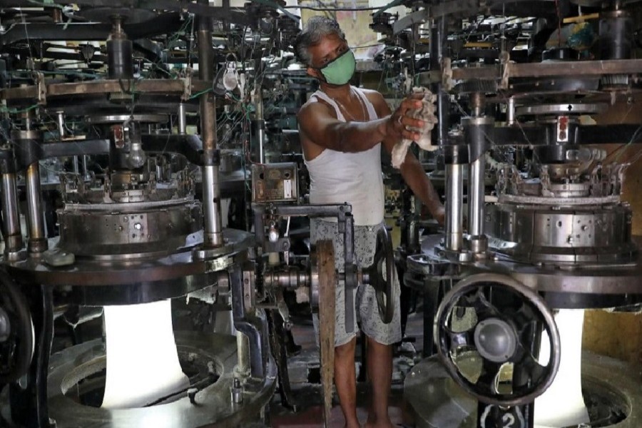 A worker wearing a protective face mask cleans a machine inside an undergarment factory after it was re-opened after a weeks-long shutdown to slow the spread of coronavirus disease (COVID-19), in Kolkata, India, April 20, 2020. — Reuters