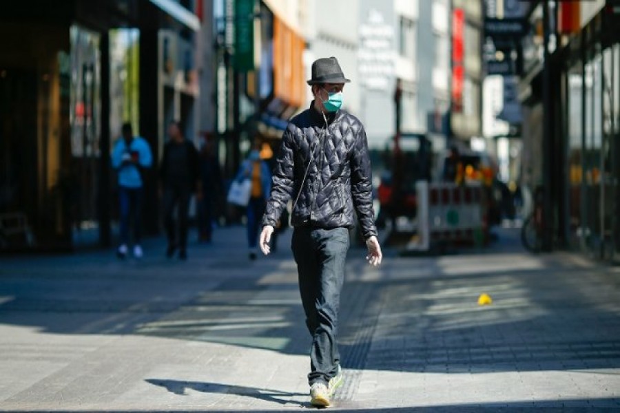 A man, wearing a protective mask and gloves, walks at the shopping district "Hohe Strasse", as the spread of the coronavirus disease (COVID-19) - Reuters photo