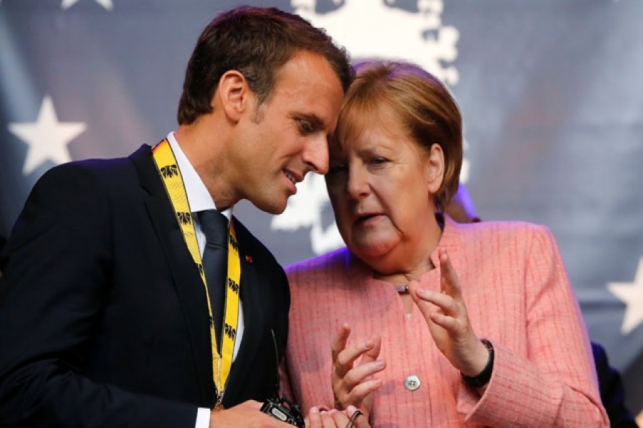 French President Emmanuel Macron speaks with German Chancellor Angela Merkel after being awarded the Charlemagne Prize for "European vision" in Aachen, Germany, May 10, 2018. Reuters