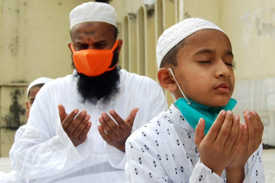 Devotees, wearing masks and maintaining physical distance, offer Munajat after taking part in Eid prayers at Baitul Mukarram National Mosque in the capital on Monday — Focus Bangla photo