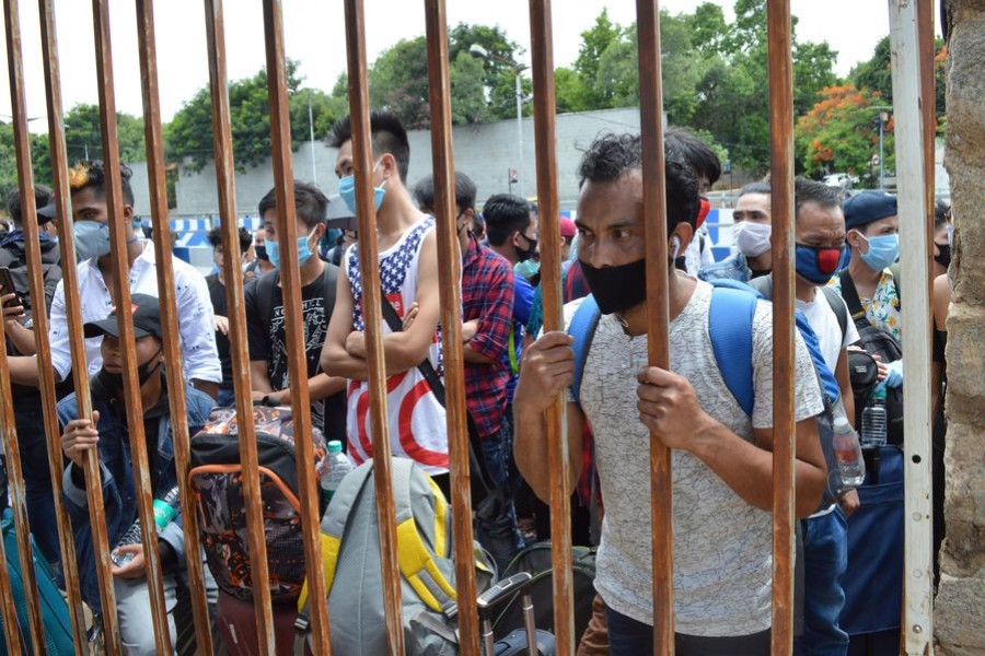 Migrant workers from different Indian states gather and wait to board buses for their destinations during the coronavirus lockdown in Bangalore, India, May 23, 2020. (Str/Xinhua)