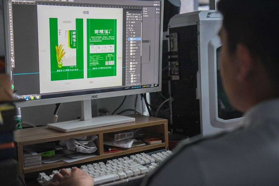 A staff member designs the package for agricultural products at the Liuyang e-commerce business poverty alleviation service center in Liuyang, central China's Hunan Province, May 15, 2020. (Xinhua/Chen Zeguo)