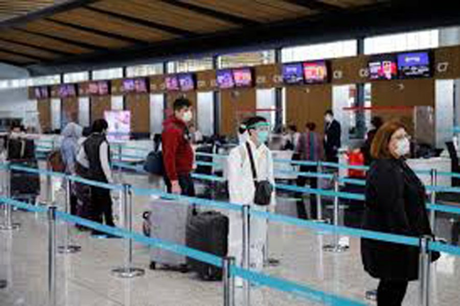 A passenger wearing a protective suit stands in a queue the Istanbul Airport during the first day of resumed domestic flights which are halted since March 26 amid the spread of the coronavirus disease (COVID-19), in Istanbul, Turkey June 01, 2020. REUTERS/Umit Bektas/File Photo