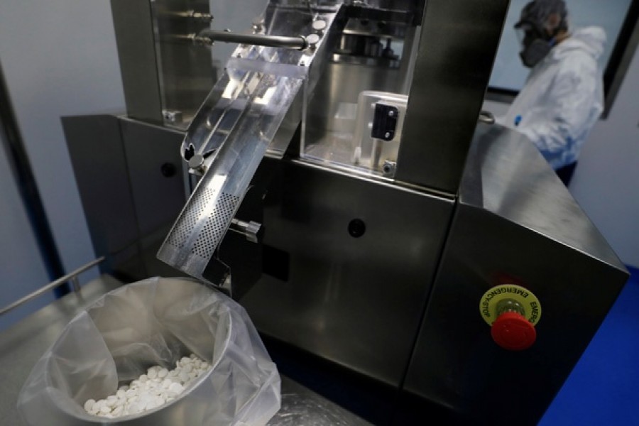 A lab technician wearing a full-face mask and a protective suit works on investigational coronavirus disease (COVID-19) treatment drug "Favipiravir" at Eva Pharma Facility in Cairo, Egypt June 25, 2020. REUTERS