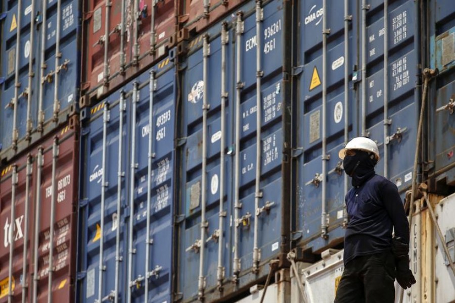 A worker stands next to shipping containers on a ship at a port in Bangkok, Thailand, March 25, 2016 — Reuters/Files