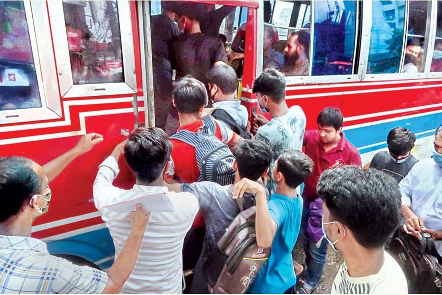 Paying no heed to social distancing norms amid the Coronavirus outbreak, commuters scramble to get on a bus in Gandaria area of the city on Thursday — FE photo by Shafiqul Alam