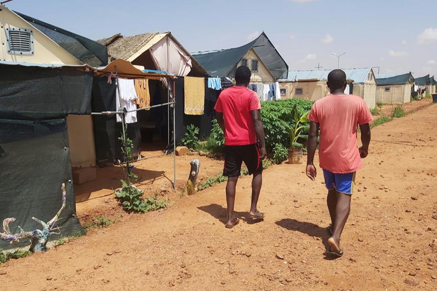 Two men walk along a path in the Hamdallaye refugee camp, amid the Covid-19 pandemic, in Niger on July 29, 2020 — UNHCR Handout via REUTERS