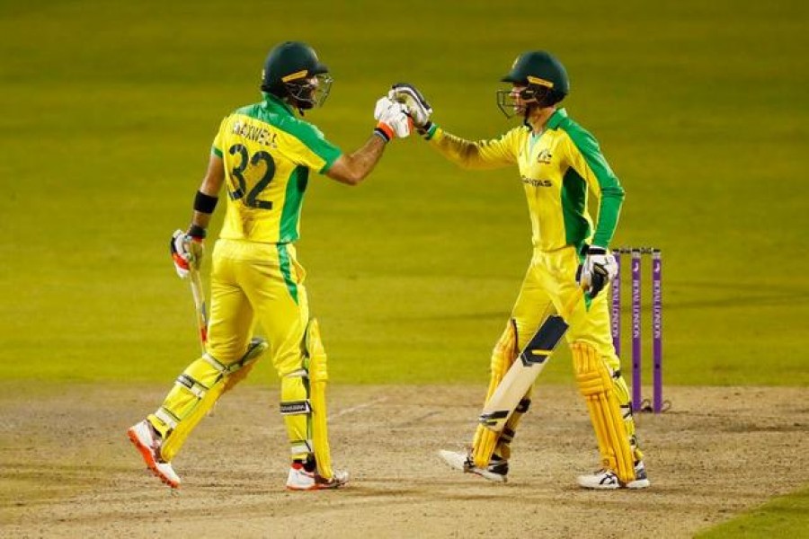 Australia's Alex Carey celebrates his century with Glenn Maxwell — Pool via Retuers