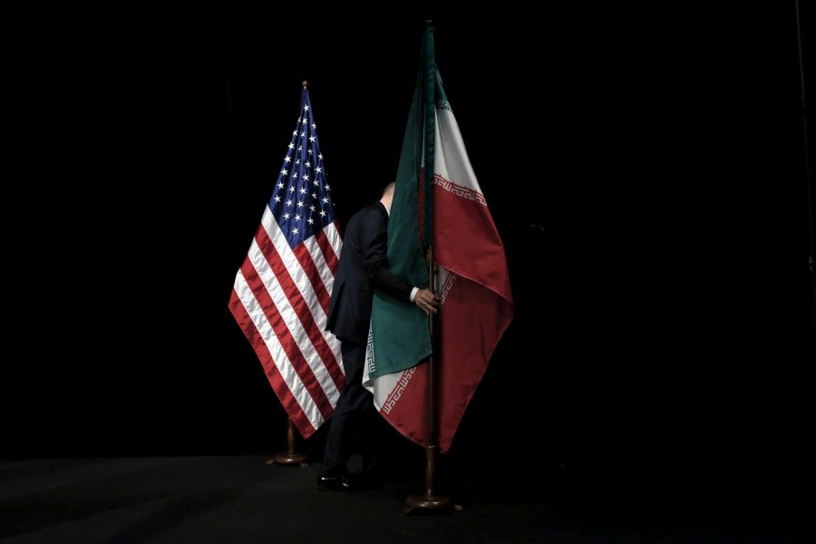 A staff member removes the Iranian flag from the during Iran nuclear talks at the Vienna International Center in Vienna, Austria on July 14, 2015 — Reuters/Files