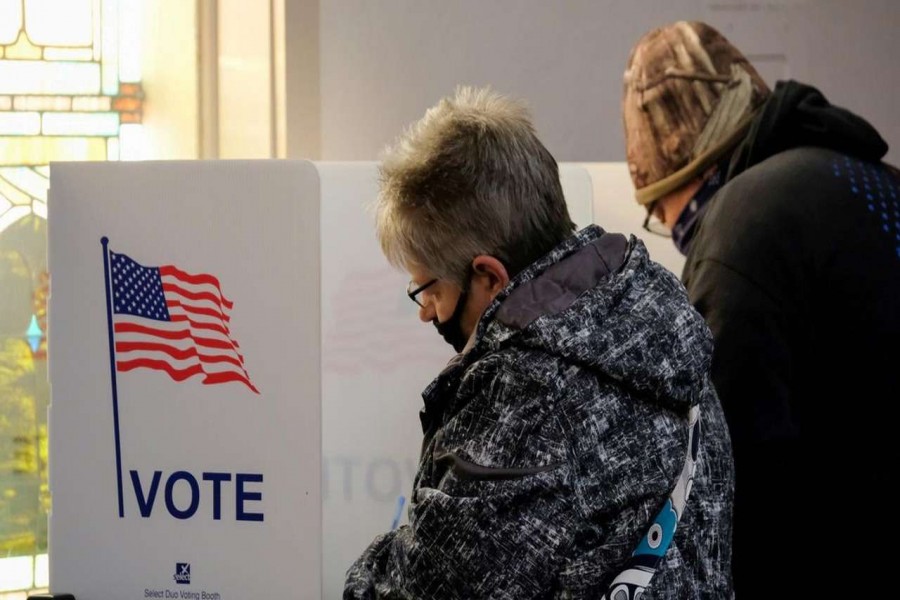 People fill in ballots at a voting booth during the 2020 U.S. presidential election on election day in New Richmond, Ohio, U.S. November 3, 2020. REUTERS/Jeffrey Dean