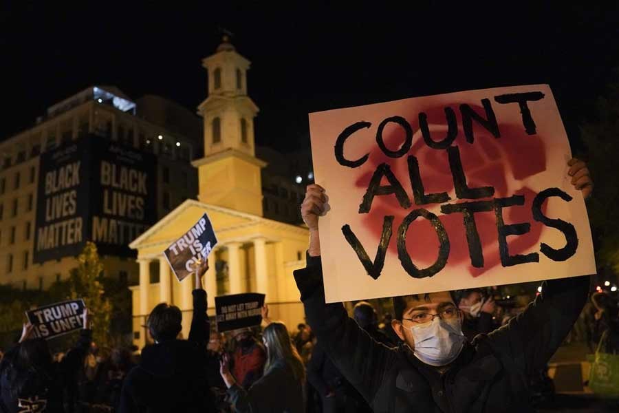 A demonstrator showing a sign while waiting for election results at Black Lives Matter Plaza on Tuesday in Washington –AP Photo