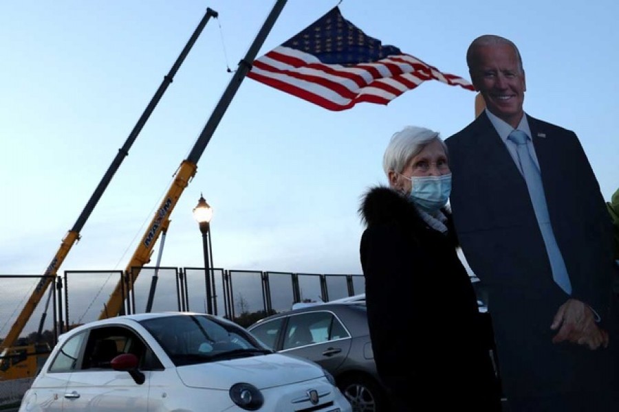 Jo Lawlor of Pennsylvania (L), a lifelong Republican who is a Biden supporter, poses for photographs with a cutout of former Vice President Joe Biden near the site where Biden and Senator Kamala Harris hope to celebrate their victory in the US presidential race in Wilmington, Delaware, US, November 05, 2020 — Reuters