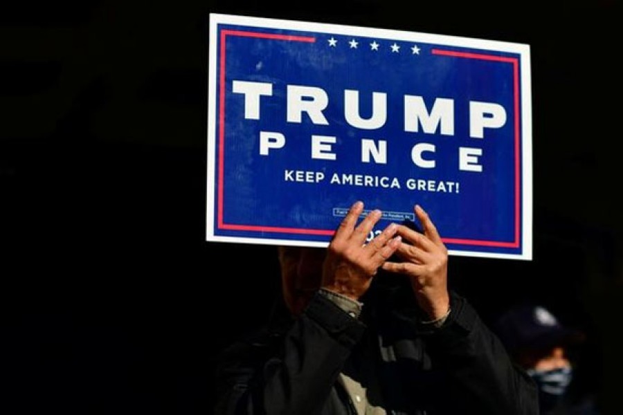 A Trump supporter clutches a campaign sign with both hands after Democratic presidential nominee Joe Biden overtook President Donald Trump in the Pennsylvania general election vote count across the street from where ballots are being counted, three days after the 2020 US presidential election, in Philadelphia, Pennsylvania, US, November 6, 2020. REUTERS/Mark Makela