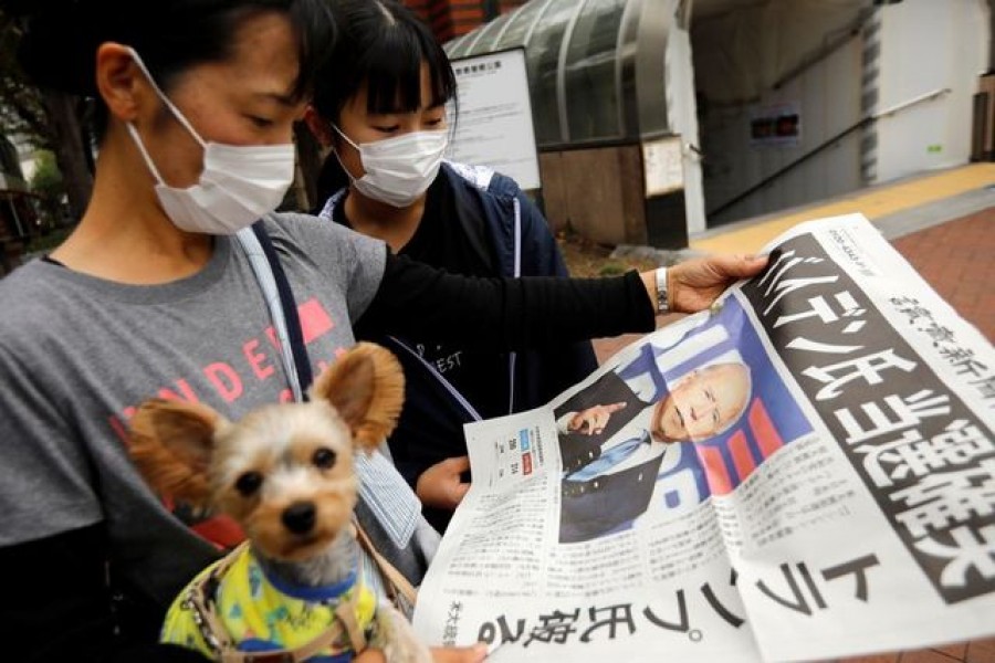 People read an extra edition of a newspaper reporting that Democratic US presidential nominee Joe Biden is projected to win the 2020 US presidential election, in Tokyo, Japan, November 8, 2020 — Reuters