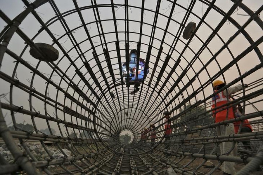 Labourers work at the construction site of a bridge being built for metro rail in New Delhi, India on November 30, 2015 — Reuters/Files