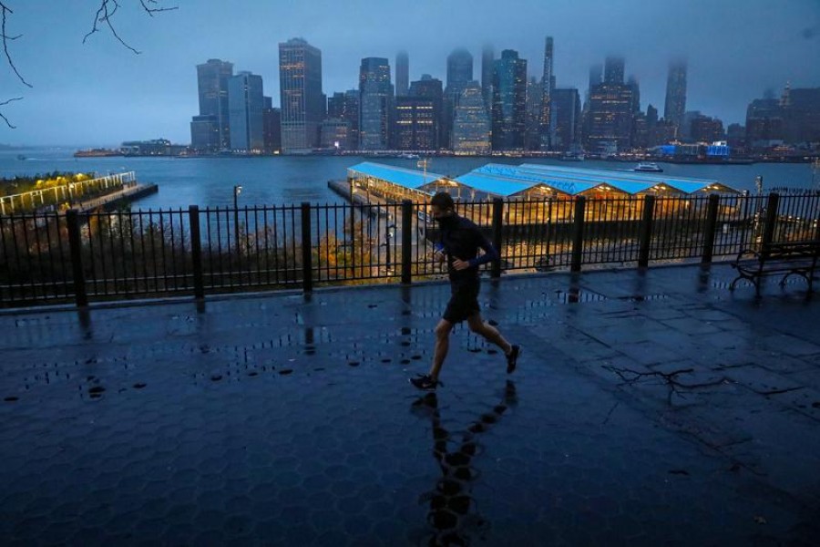 A man runs along the Brooklyn Heights Promenade as fog covers lower Manhattan in New York, U.S. November 30, 2020. REUTERS/Brendan McDermid