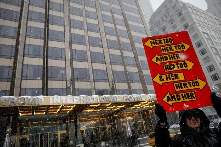 A protester holds a sign up during a #MeToo demonstration outside Trump International hotel in New York City, NY, US, December 9, 2017 — Reuters/Files