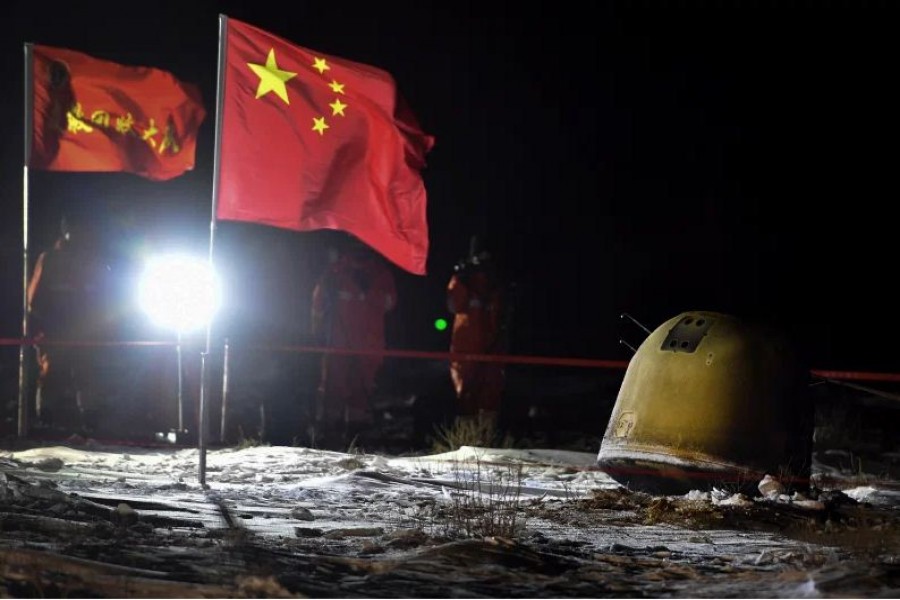 In this photo released by Xinhua News Agency, recovery crew members film the capsule of the Chang'e 5 probe after its successful landed in Siziwang district, north China's Inner Mongolia Autonomous Region on Thursday, Dec. 17, 2020. Ren Junchuan/Xinhua via AP