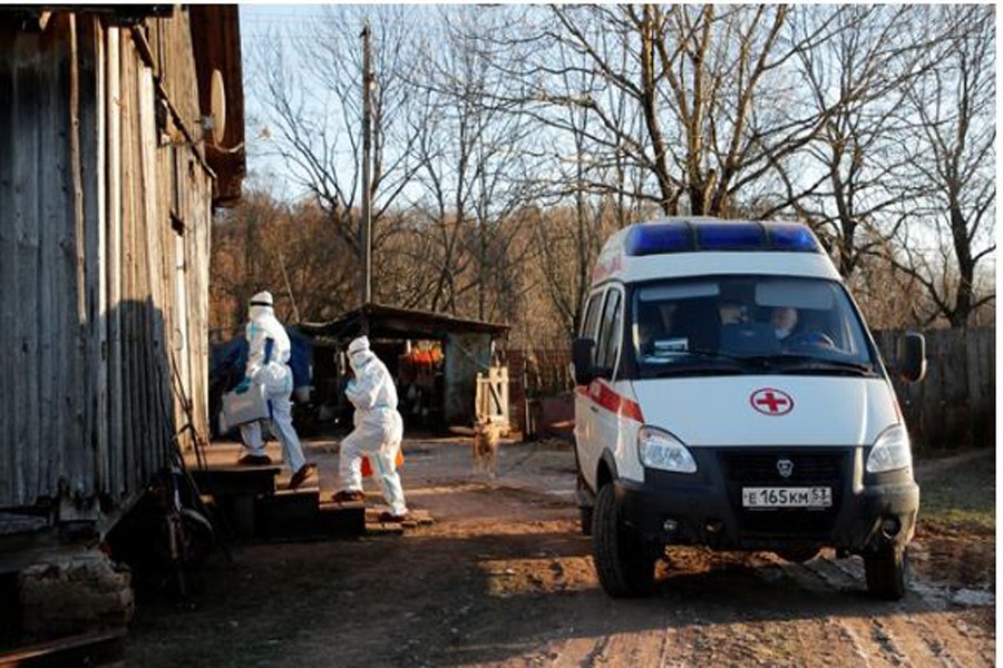 Paramedics wearing personal protective equipment (PPE) enters the house of a patient, amid the outbreak of the coronavirus disease (COVID-19) in the village of Vybiti, Novgorod Region, Russia Dec 10, 2020. REUTERS   