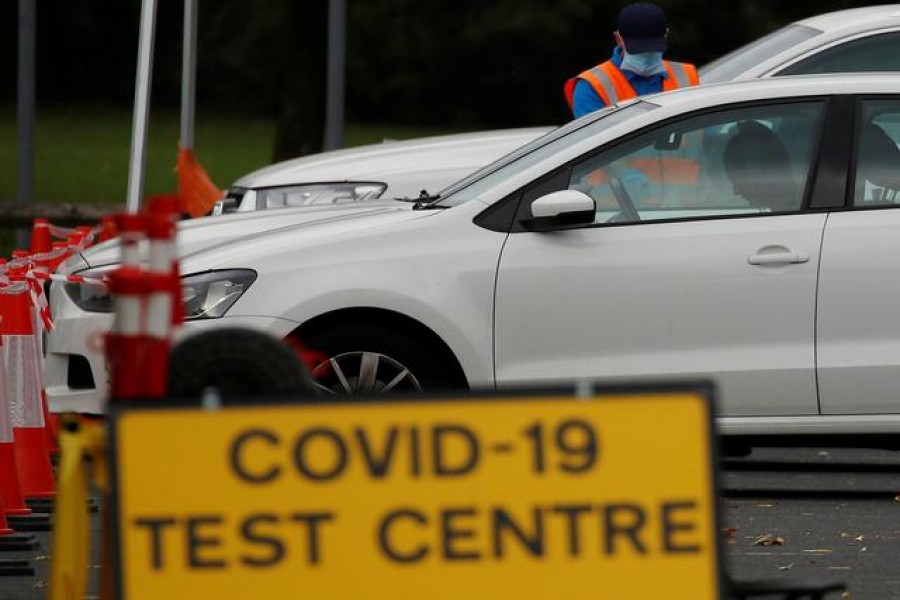 An NHS test and trace worker talks to a driver at a drive-through testing centre following the outbreak of the coronavirus disease (Covid-19) in Bolton, Britain, September 22, 2020. Picture taken September 22, 2020. REUTERS/Phil Noble