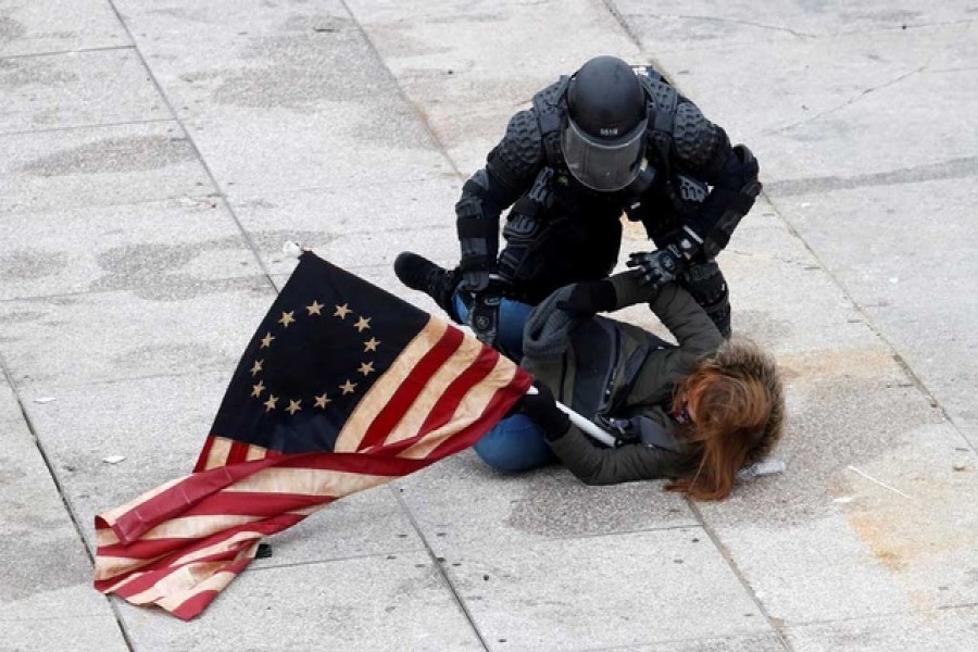 A police officer detains a pro-Trump protester as mobs storm the US Capitol, during a rally to contest the certification of the 2020 US presidential election results by the US Congress, at the US Capitol Building in Washington, US, January 6, 2021. REUTERS/Shannon Stapleton