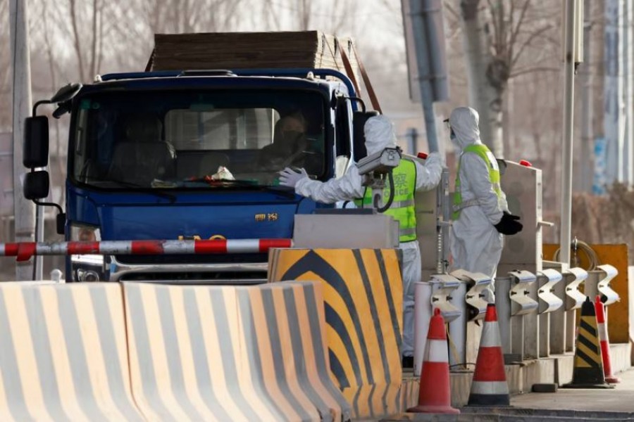 FILE PHOTO: Police officers in PPE stop a car coming from Hebei province at a checkpoint, following the coronavirus disease (COVID-19) outbreak, on the outskirts of Beijing, China January 12, 2021. REUTERS