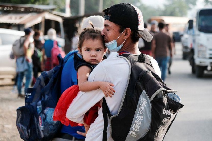 A man kisses his daughter as he takes part with other Hondurans in a new caravan of migrants, set to head to the United States, in Cofradia, Honduras, January 15, 2021 — Reuters