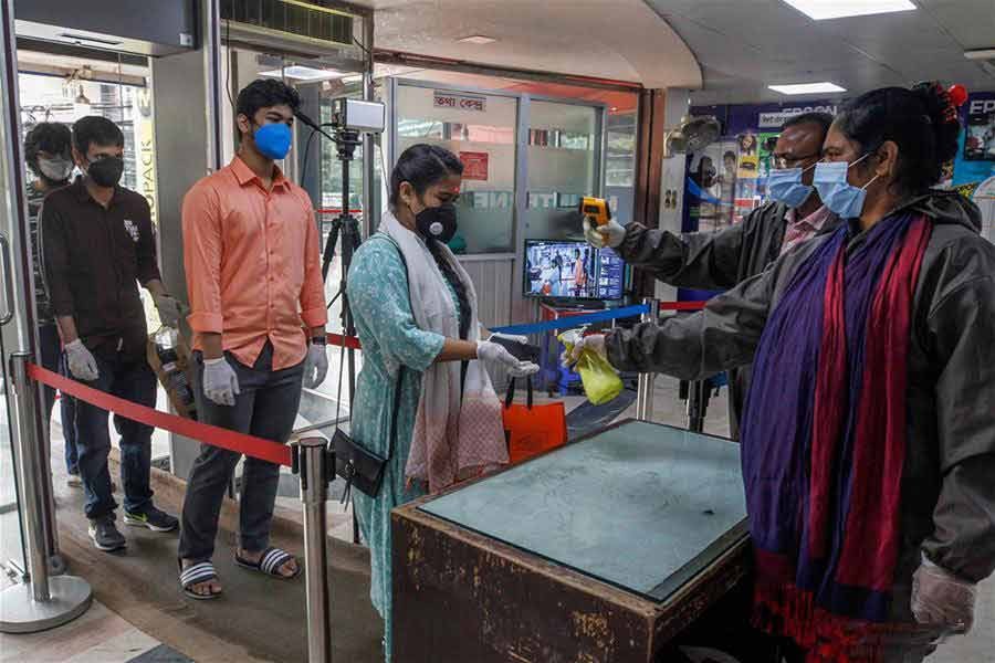 People have their temperature checked while entering a market in Dhaka, Bangladesh on May last    —Xinhua