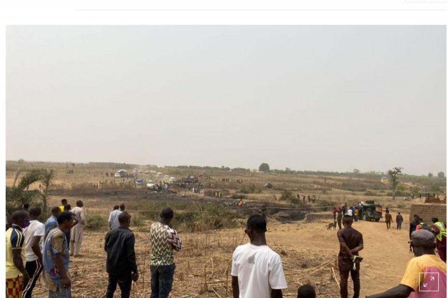 People watch as rescuers inspect the debris from a Nigerian air force plane, which crashed while approaching the Abuja airport runway according to aviation minister, in Abuja, Nigeria February 21, 2021. REUTERS/Abraham Achirga