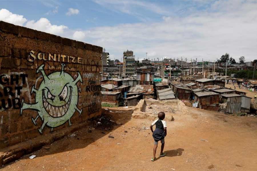 A boy walks in front of graffiti promoting the fight against the coronavirus disease (COVID-19) in the Mathare slums of Nairobi of Kenya last year -Reuters file photo