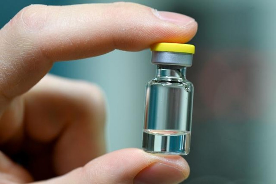 A worker of German vaccine maker IDT Biologika shows a sample ampoule during the visit of German Health Minister Jens Spahn in Dessau Rosslau, Germany, November 23, 2020, as the spread of the coronavirus disease (Covid-19) continues — Hendrik Schmidt/Pool via Reuters/File Photo