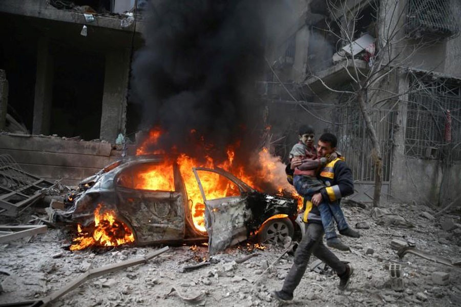 FILE PHOTO: A Syria Civil Defence member carries a wounded child in the besieged town of Hamoria, Eastern Ghouta, in Damascus, Syria Janauary 06, 2018. REUTERS/ Bassam Khabieh