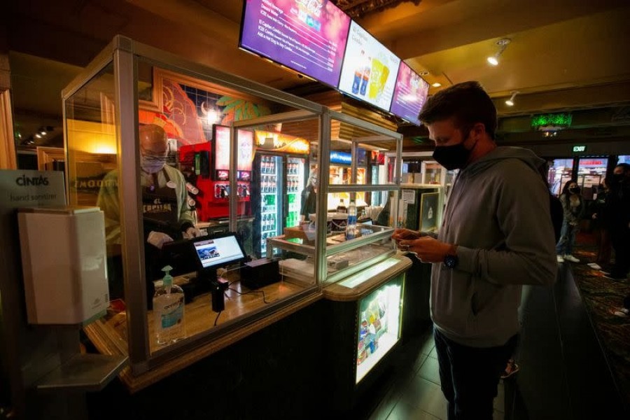 A moviegoer shops at concession stands retrofitted with plexiglass partitions before the movie "Raya and the Last Dragon" on the reopening day of El Capitan theatre during the outbreak of the coronavirus disease (Covid-19), in Los Angeles, California, US on March 19, 2021 — Reuters photo