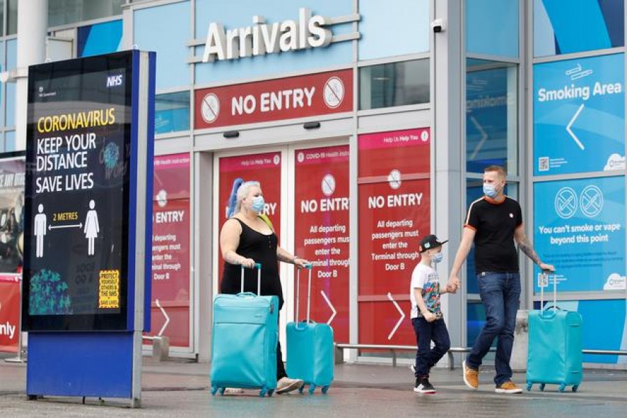 FILE PHOTO: Passengers wearing protective masks are pictured after arriving at Birmingham Airport following the outbreak of the coronavirus disease (COVID-19) in Birmingham, Britain July 27, 2020. REUTERS/Phil Noble