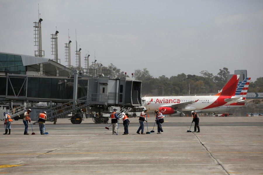 Workers sweep ashes from the Pacaya volcano at the tarmac of La Aurora International Airport in Guatemala City, Guatemala on March 23, 2021 — Reuters photo