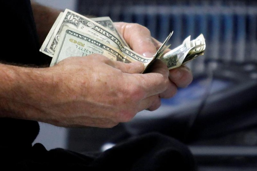 FILE PHOTO: A customer counts his cash at the register while purchasing an item at a Best Buy store in Flushing, New York March 27, 2010 - Reuters